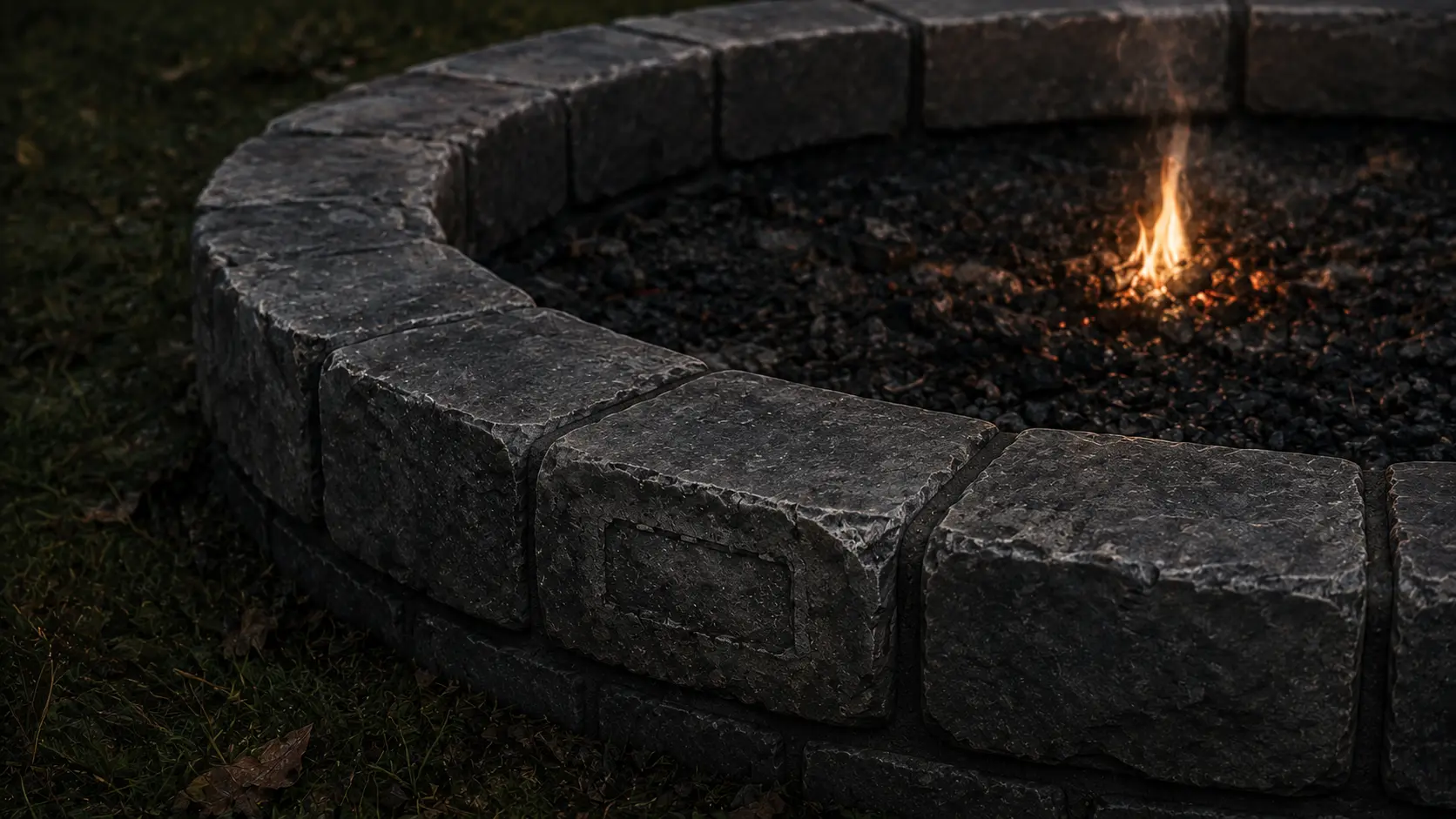Close on the fire ring itself: mismatched stones, mortar set by hand, one block still carrying the ghost of a stamped address.